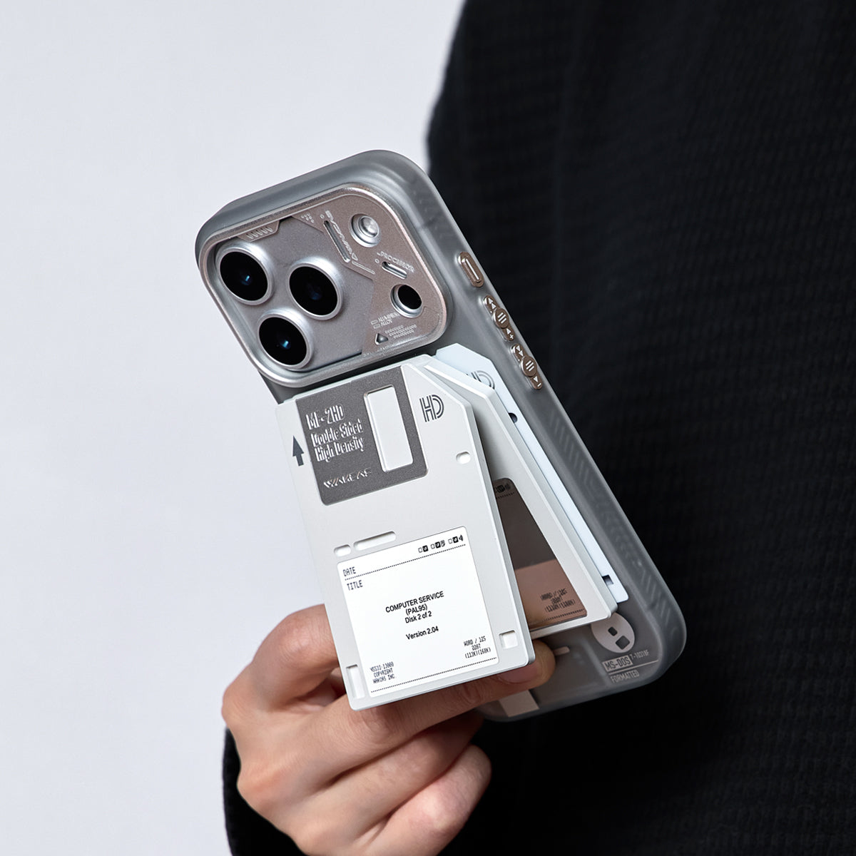 Floppy disk stand being attached to the back of an iPhone