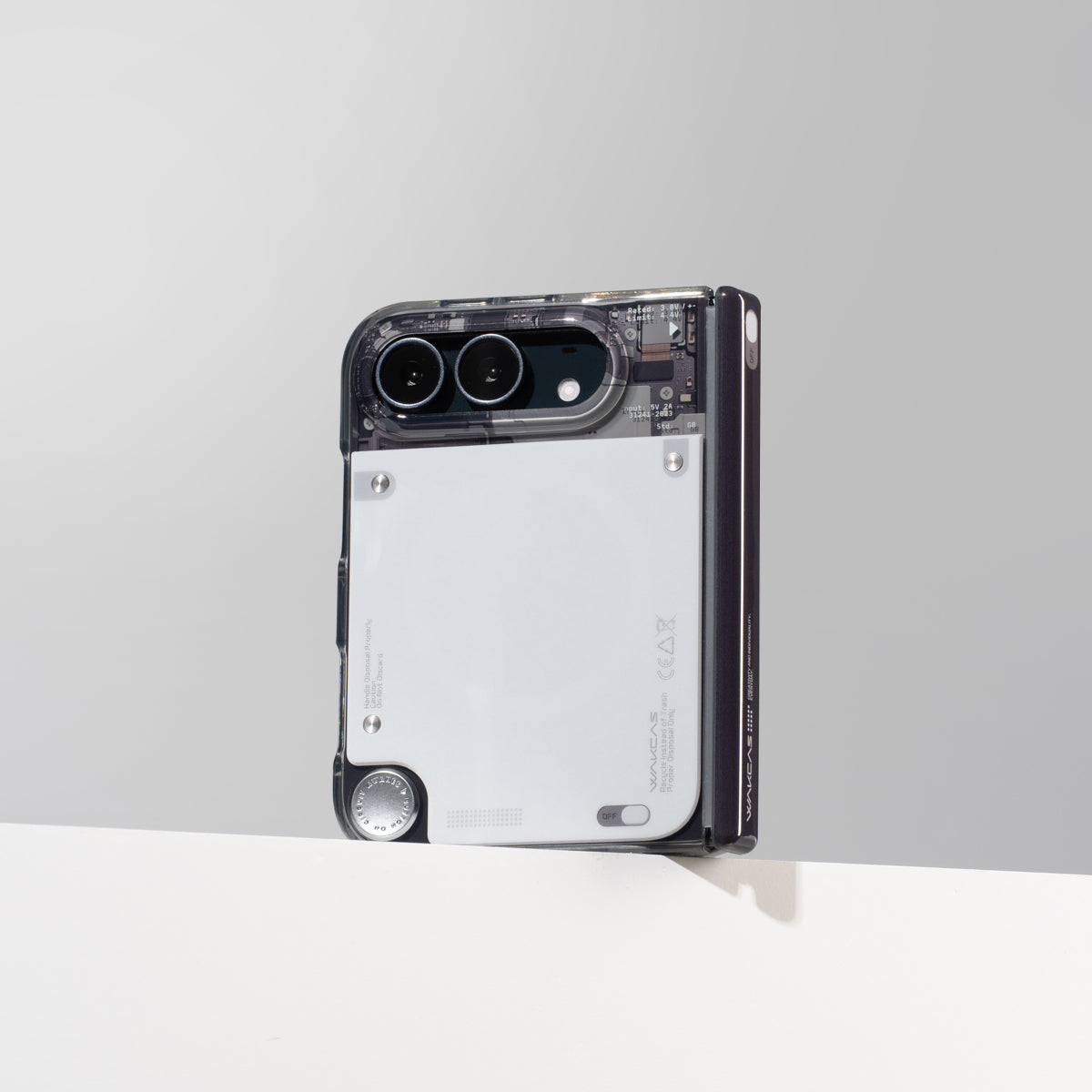 iPhone Duo in the gloss see-through case standing against a gray wall