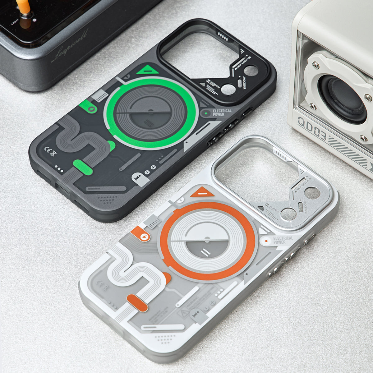 Black-green and white-orange cases on a desk