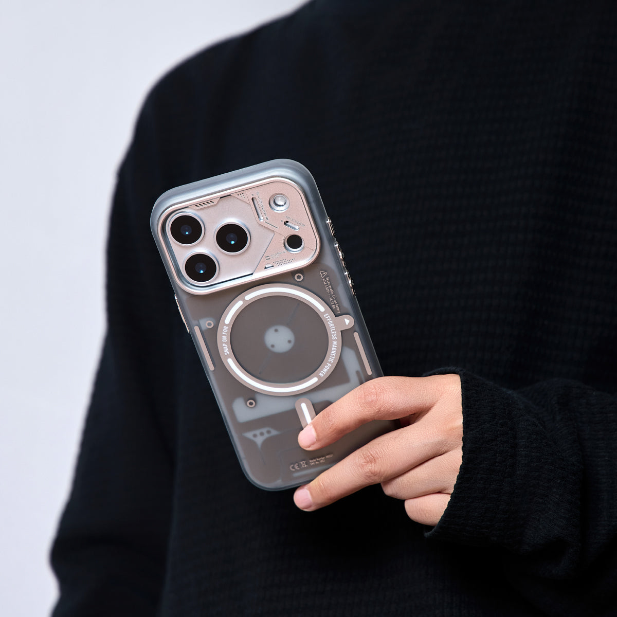 Person holding the frosted gray case with a rose-tone camera frame