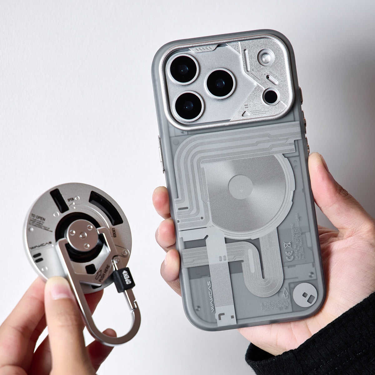 Hands holding the frosted case and the carabiner stand