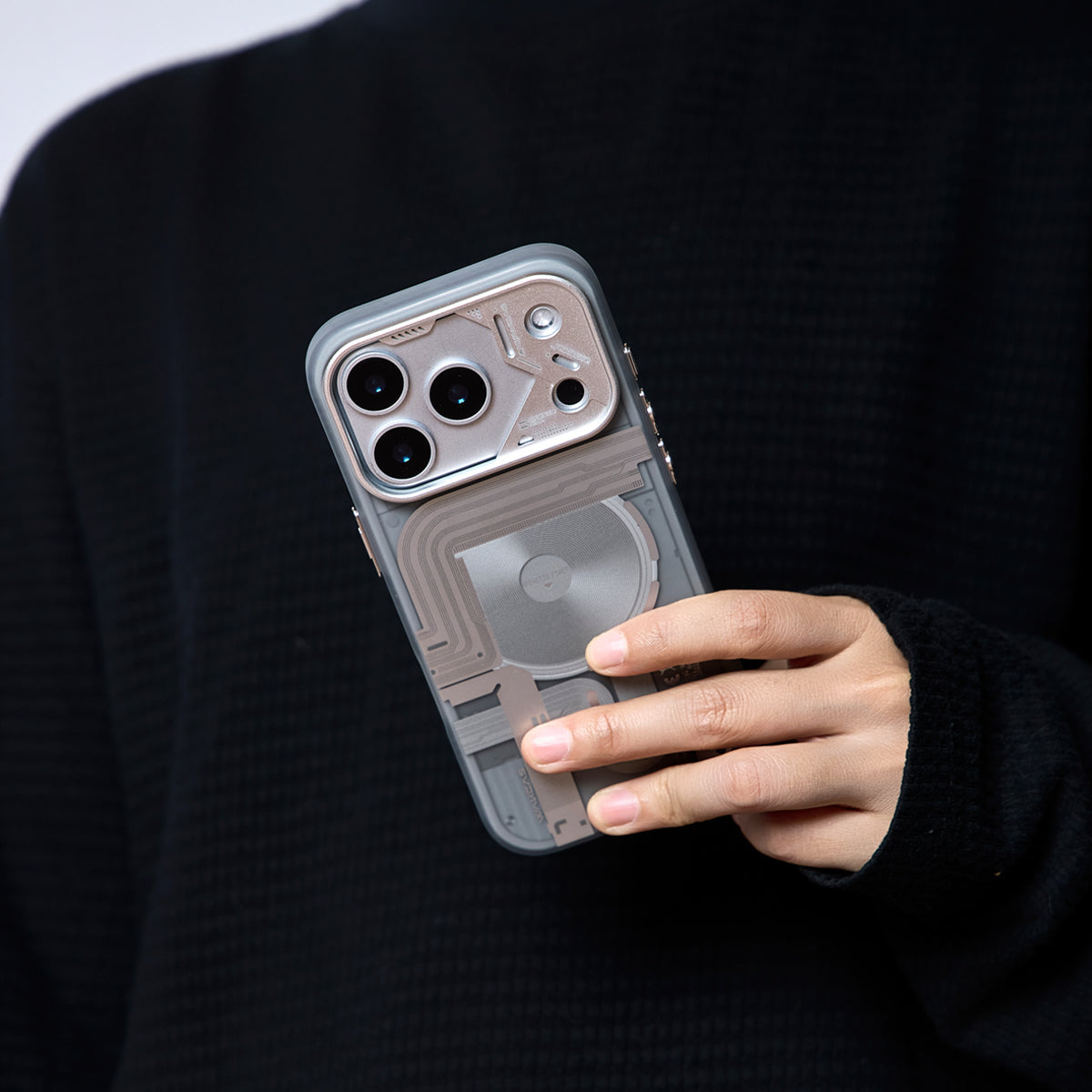 Hand holding the frosted mechanical case against black clothing
