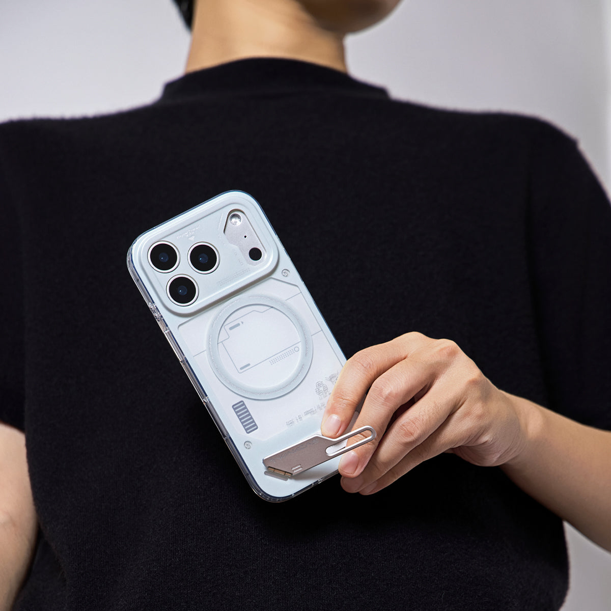 Person holding the grey case and opening the kickstand
