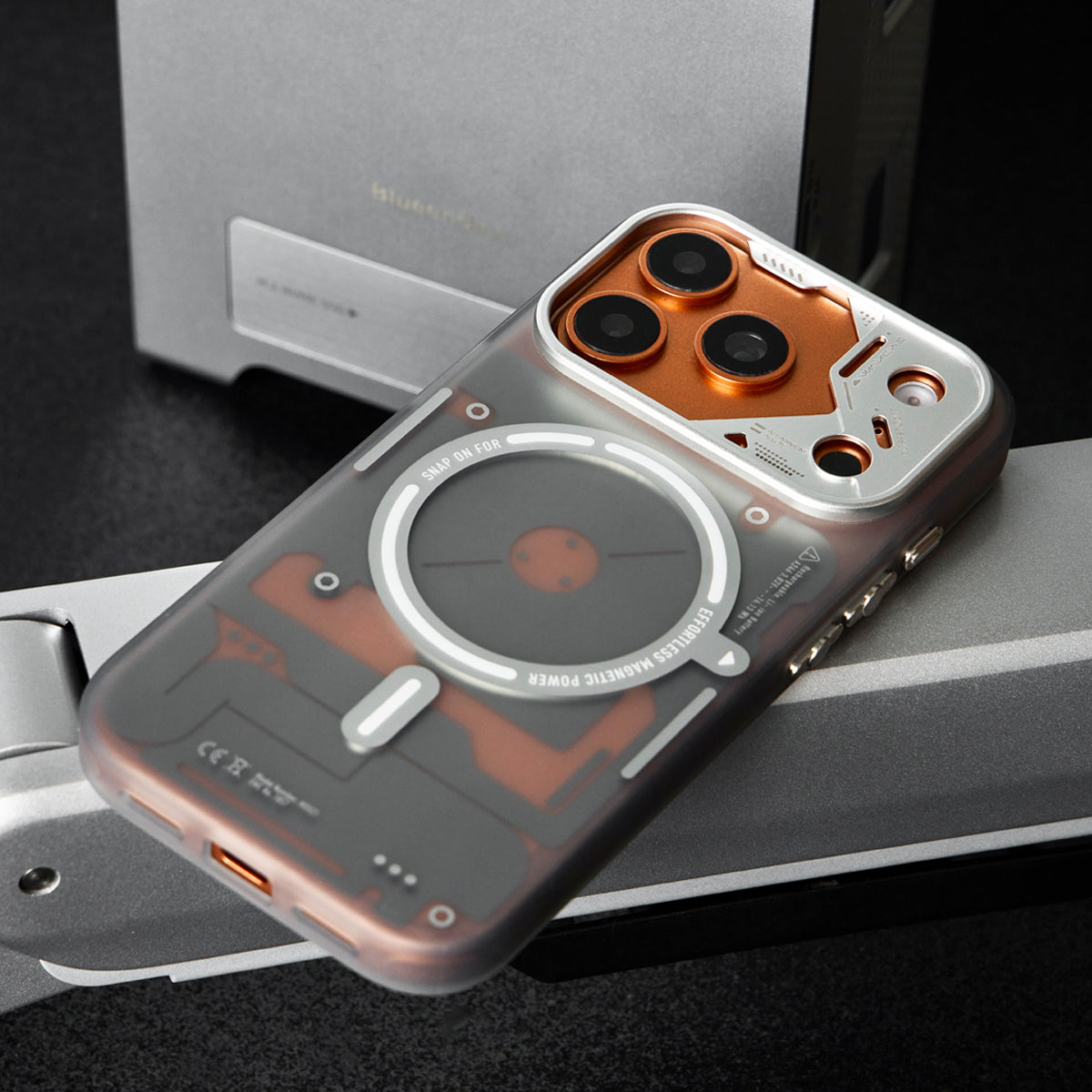 Frosted case with orange camera frame resting on a monitor arm