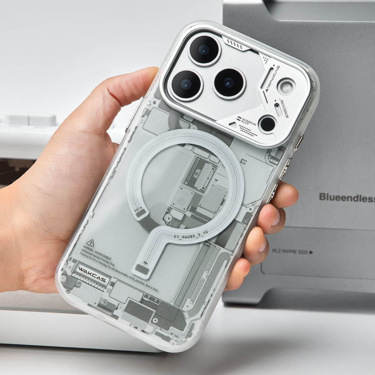 Hand holding the grey circuit board case, back view with camera cutouts