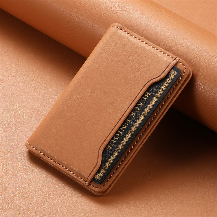 Close-up of the tan magnetic card holder resting on a leather surface