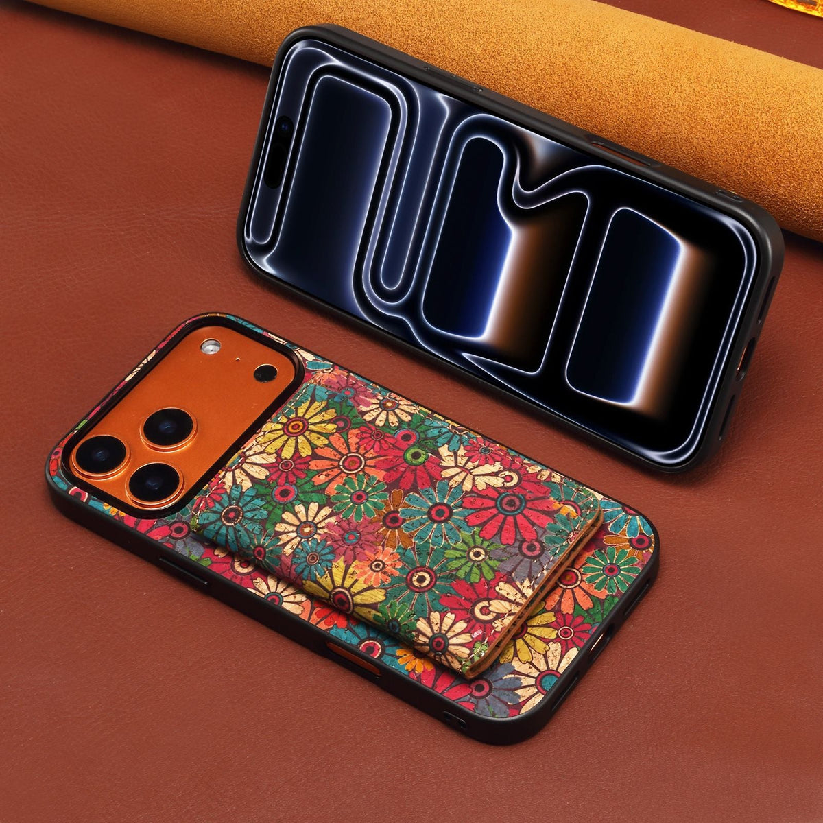 Floral card wallet case lying on a leather surface next to an iPhone screen