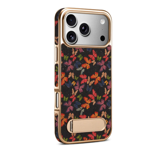 iPhone 17 Pro Max butterfly print case in black with gold-tone frame and fold-out kickstand