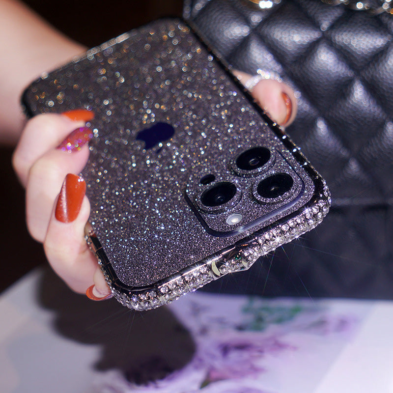 Black gradient glitter iPhone case with rhinestone edge held next to a quilted bag