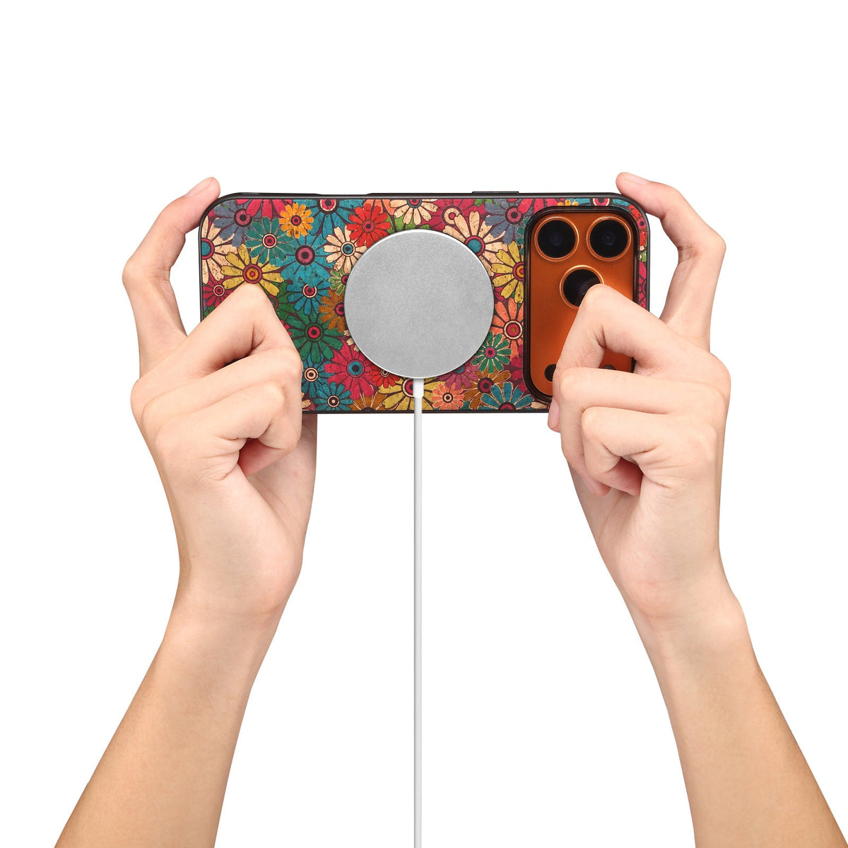 Floral case with the wallet removed, held over a round magnetic charging pad
