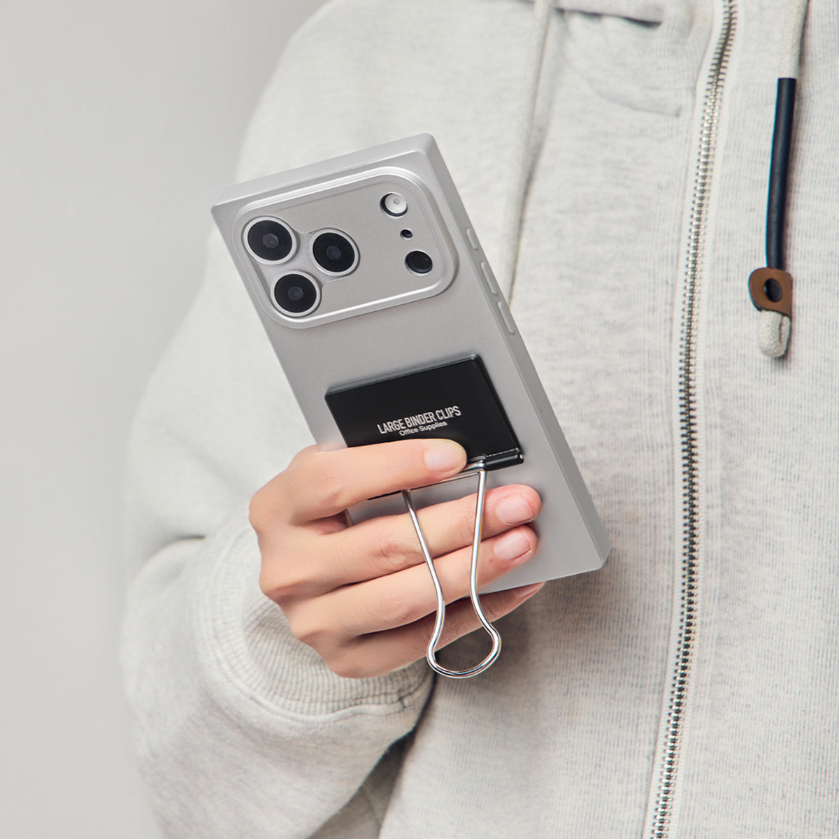 Hand holding the silver binder clip case