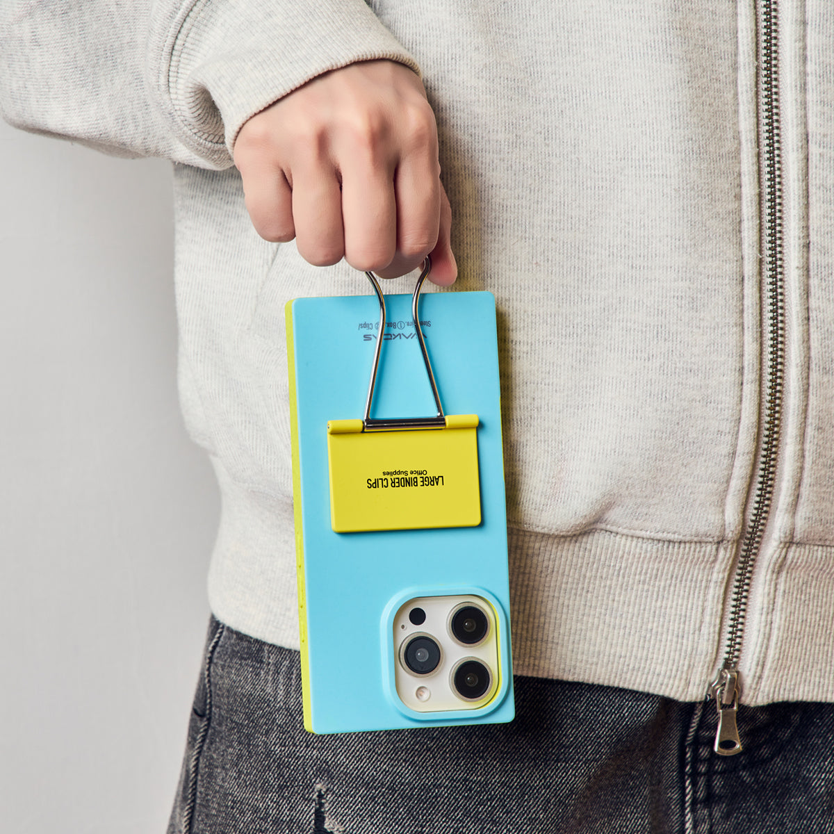 Hand carrying the phone by the blue case's binder clip